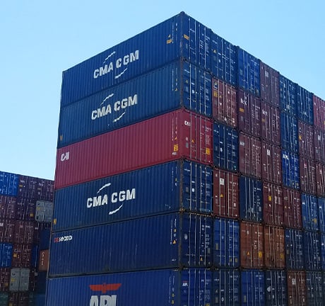 A stack of shipping containers lined up in a container yard